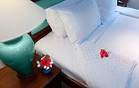 A pillow and flower on a bed